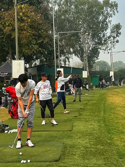 A full range of golfers, with some in mid-swing, creating a dynamic action shot.