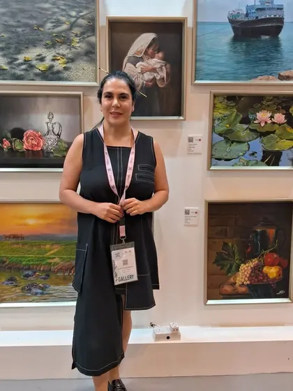 Artist Zeinab Sarkhosh at her booth at World Art Dubai, surrounded by her exquisite collection that spans history, nature, and hyperrealism.