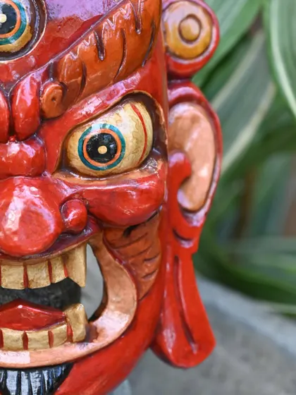 A close-up of a traditional Nepalese mask, highlighting the hand-painted eyes and fierce expression. The artists use natural colors to bring out the unique character and emotion of each mythical figure.
