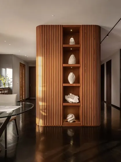 In the 'Rambagh' residence, we used curved, fluted wood panelling to create a warm, enveloping core that separates living areas while maintaining an open feel. This structure doubles as a display for curated art, reflecting our focus on integrating bespoke architectural elements that are both functional and beautiful.