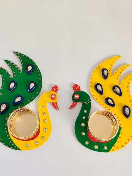 The finished peacock T-light holders, beautifully painted and decorated with gems. They look stunning and are ready to light up the festival.