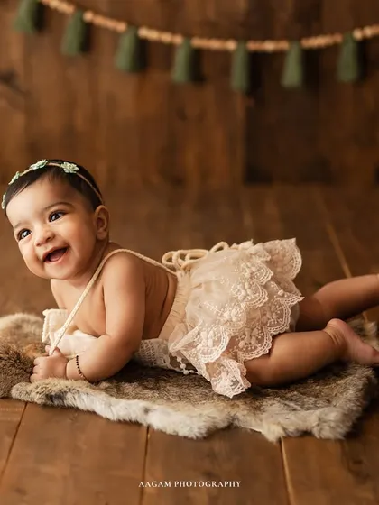 A priceless smile from a baby girl during her tummy time. The soft fur rug and wooden floor add a warm, rustic touch to this milestone portrait.