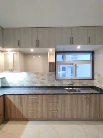 A full view of the simple and functional kitchen, showcasing the ample storage and clean design.
