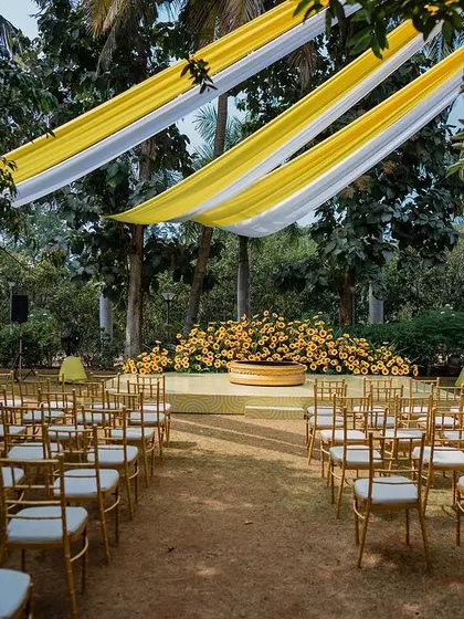 The beautiful outdoor setup for a Haldi ceremony at Panchavati Pavilion, with vibrant yellow drapes and lush greenery creating a perfect festive atmosphere.