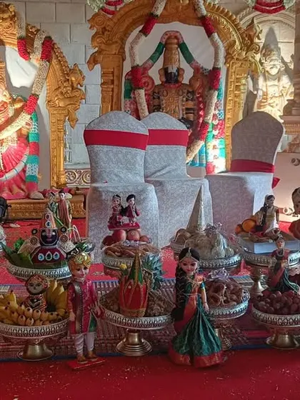 A traditional plate decoration setup inside a temple hall. The gifts are arranged in front of the deities, integrating the offerings into the sacred space of the ceremony.