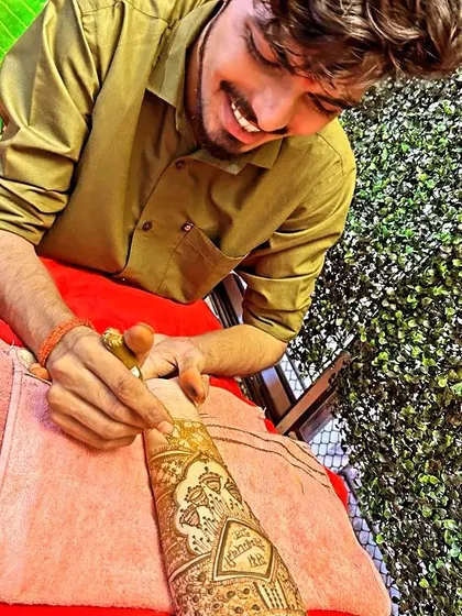 A candid shot of me smiling while working on a detailed bridal design.