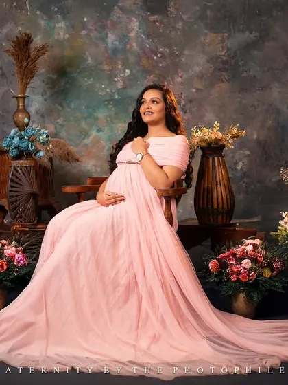 A regal portrait of the mom-to-be seated amongst a beautiful arrangement of flowers in our studio, looking like a queen on her throne.
