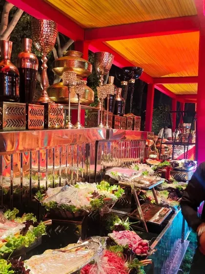 A vibrant and colorful salad bar setup for a festive night event. The counter is filled with a wide variety of fresh vegetarian salads and cold appetizers, beautifully arranged for guests to enjoy.