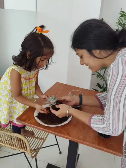 A mother and daughter working together to place a succulent in their terrarium. These moments of collaboration and connection are what make these workshops so special.