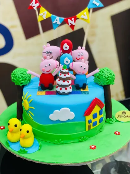 A cheerful 2.5kg Peppa Pig cake showing the whole family having a picnic in a sunny field.