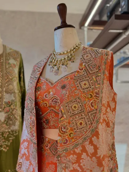 Carefully curated festive fits. This display pairs an earthy green kurta with a stunning brocade jacket set in peach and orange tones.