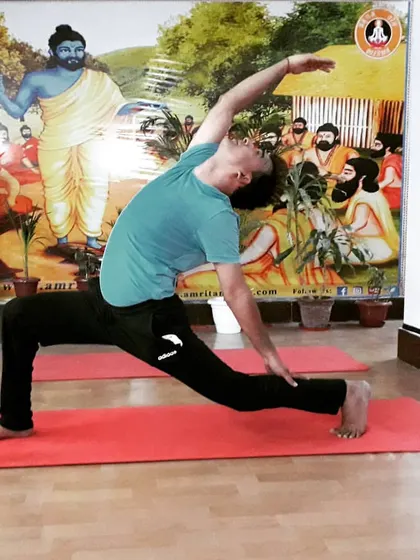 A student practices Parivrtta Parsvakonasana (Revolved Side Angle Pose) in our studio. This twisting pose detoxifies the organs and improves spinal mobility.