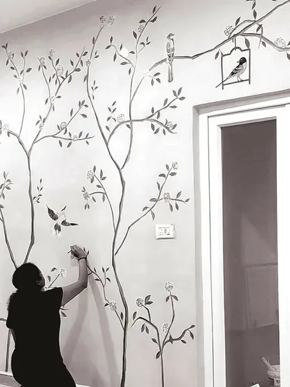 A duplicate image of me painting a delicate floral mural.