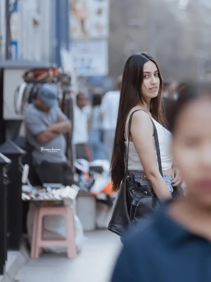 A candid moment captured on a busy Bangalore street. The composition, with the subject looking back, creates a feeling of a story unfolding.