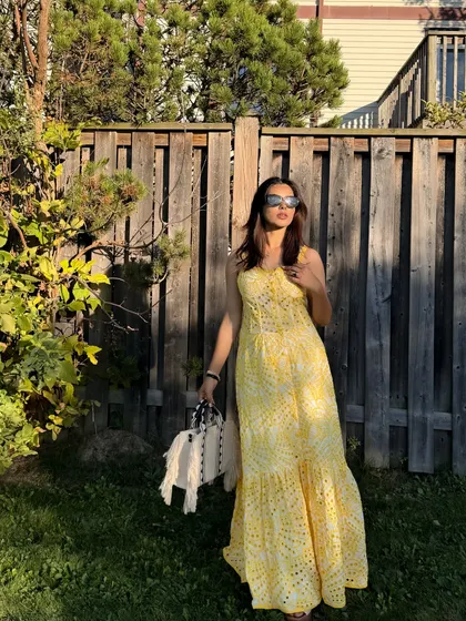 Posing in the sunny garden with the yellow Jardinvue maxi dress and a stylish handbag.