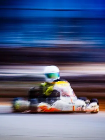 A motion-blurred shot capturing the incredible sense of speed as one of our drivers sends it into a corner during a race week.