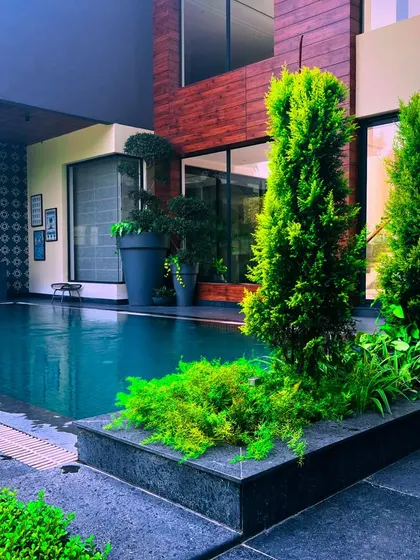 This angle shows the relationship between the house, the pool, and the landscaping, creating a cohesive and luxurious outdoor environment.