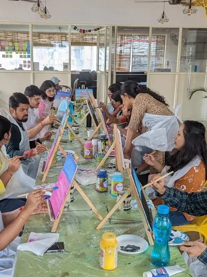 A busy canvas painting workshop in session. Our long tables and bright studio space are perfect for getting creative.