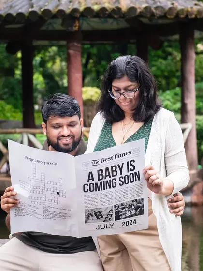 The couple reading their "Baby is Coming Soon" newspaper together. This shot adds a narrative element to the announcement, making it feel like a shared, special moment.
