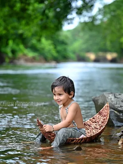 A beautiful, calm portrait of the baby in the boat, surrounded by the lush green scenery.