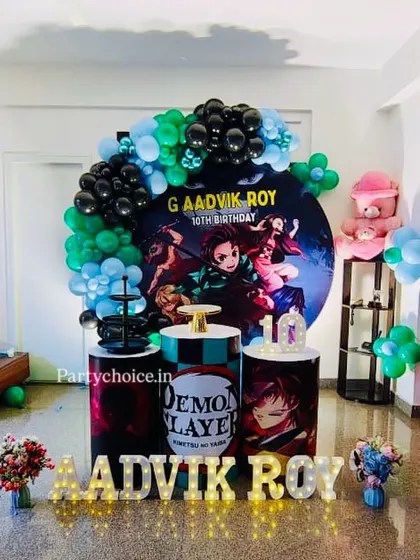 A Demon Slayer anime theme for a 10th birthday. We used a dark and dramatic color palette with a circular character backdrop, themed pedestals, and the birthday boy's name in light-up letters.