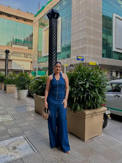 A full denim jumpsuit is a statement in itself. This one, with its halter neck and wide-leg silhouette, is a modern and powerful take on casual wear.