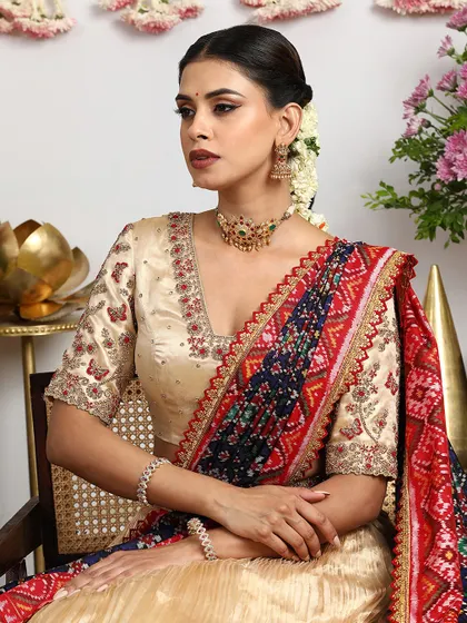 A close-up portrait showcasing the delicate butterfly embroidery on the blouse sleeves and the rich texture of the Bandhani dupatta.