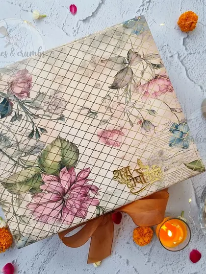The exterior of my floral-themed Diwali gift box. It comes with a beautiful ribbon and a golden 'Shubh Diwali' tag, setting a festive tone before it's even opened.