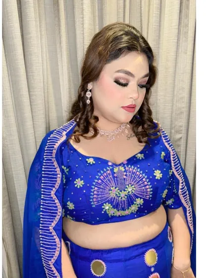A close-up portrait highlighting the client's makeup and the detailed work on the blouse. The outfit provides the perfect canvas for a full glam look.