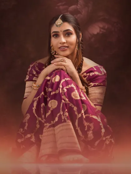 A warm, glowing portrait of Sapthami Gowda, her expressive eyes and beautiful saree creating a captivating image.