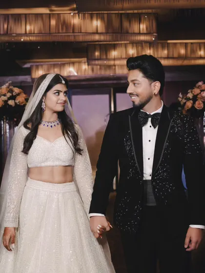 A candid shot of the couple sharing a happy glance as they walk hand-in-hand. This captures the joy and connection during a formal evening event.