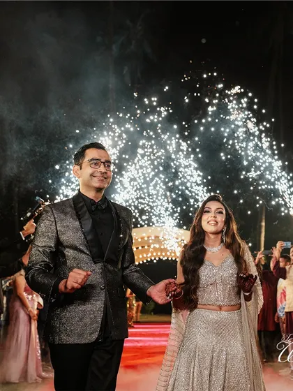 A wide shot of the couple's sparkling entrance, surrounded by their cheering friends and family.