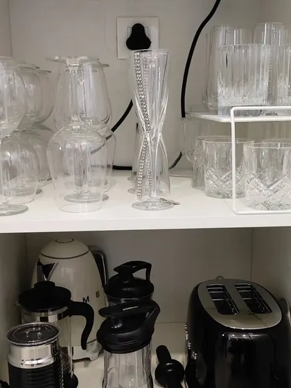 Even a small appliance cabinet can be organized. A simple shelf riser creates a second level of storage, allowing a toaster and kettle to be stored neatly without taking up counter space.