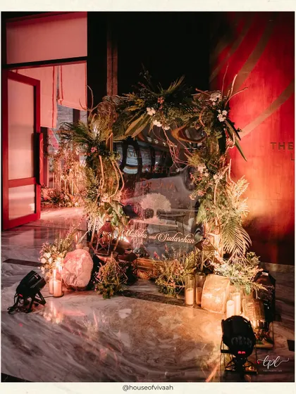 An entrance arch for the Sangeet, crafted from rustic branches, foliage, and soft candlelight, creating a natural and enchanting welcome for guests.