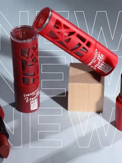 A dynamic arrangement of red lipstick products with a "NEW" graphic overlay, perfect for a product launch announcement.