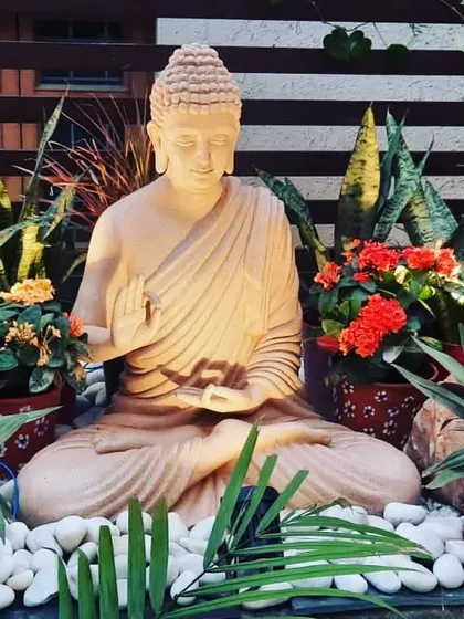 The same Buddha statue with lighting that accentuates its peaceful features, making it a stunning focal point at dusk.