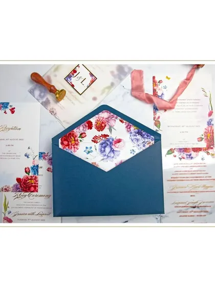 This suite combines a vibrant floral design on paper inserts with a modern acrylic main invitation. The contrast between the materials, tied together with a custom wax seal and silk ribbon, creates a unique and memorable piece.