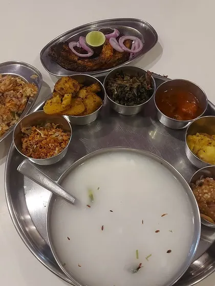 A glimpse into the heart of Odia tradition, our authentic Pakhala Thali. This celebratory meal features fermented rice served with an array of accompaniments like fried fish, various bhajas (fries), and salads, offering a truly soulful dining experience.