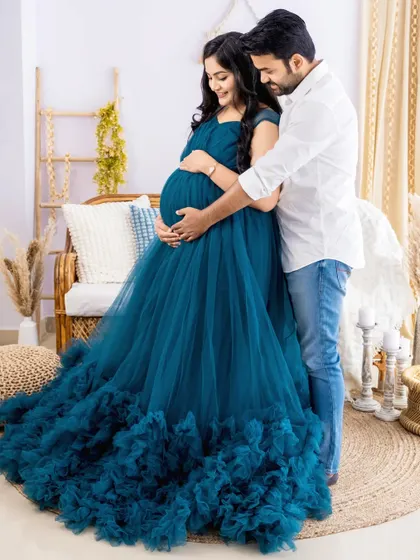 Our studio wardrobe includes a variety of stunning maternity gowns, like this flowing teal dress. We want you to feel beautiful and relaxed, so we provide complimentary gowns and professional makeup services to make your maternity photoshoot an enjoyable experience.