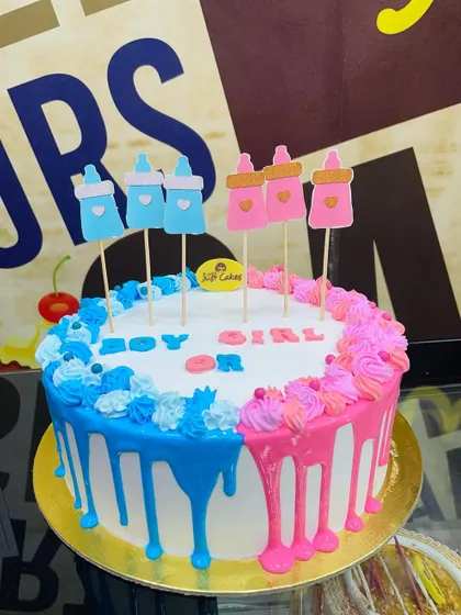 A 2kg "Boy or Girl?" gender reveal drip cake with pink and blue bottle toppers.