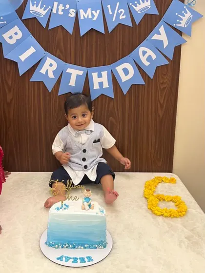 Client share! The birthday boy looking dapper next to his half birthday cake.