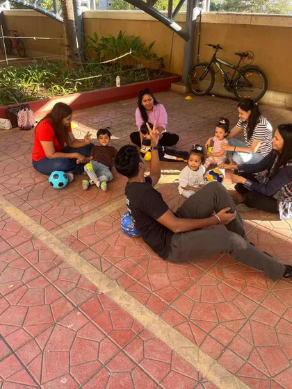 A fun, relaxed moment with toddlers, parents, and the coach sitting together. This shows the community atmosphere we build in our classes.