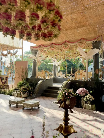 For a post-wedding vrattam function, I designed this serene Pichwai-themed decor in a farm setting. The space combines the rustic charm of a thatched roof with the elegance of traditional motifs and soft floral arrangements.