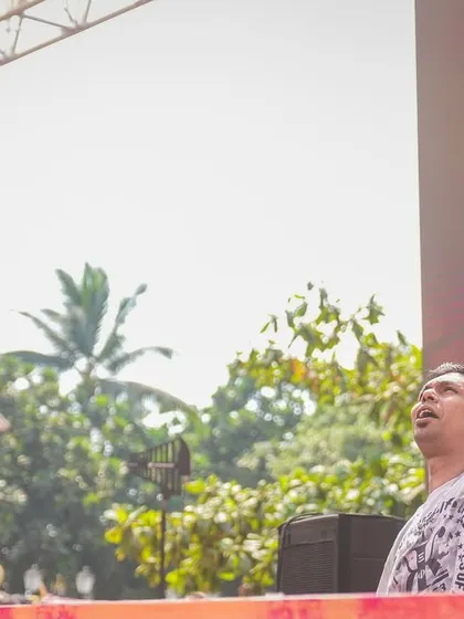One hand for the mix, one for the sky. In the zone during a daytime festival set, connecting with the massive crowd in front of me.