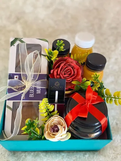 Our "Take Care" hamper is a popular choice for corporate wellness initiatives. This set includes healthy blueberry muffins, immunity-boosting juices, and other comforting items, beautifully arranged with floral accents.