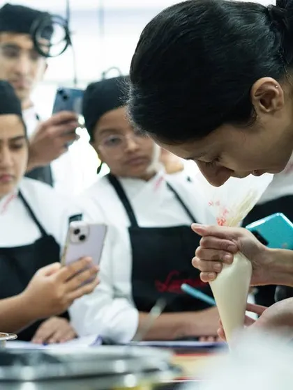 Everyone wants to capture the moment! Students recording a chef's demonstration to make sure they don't miss a single detail.