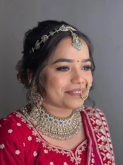 A final portrait of this stunning bride. The makeup is soft, radiant, and perfectly suited for her traditional red wedding attire.