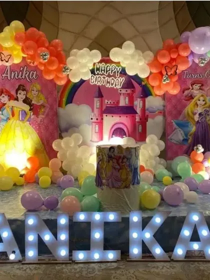 A full view of the "Anika" Disney Princess castle themed party. The stage setup includes large marquee letters and a vibrant balloon arch.