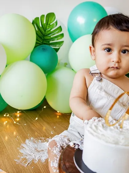 A minimalist cake smash with a simple, elegant setup. This little boy is looking right at the camera before diving into his first birthday cake.