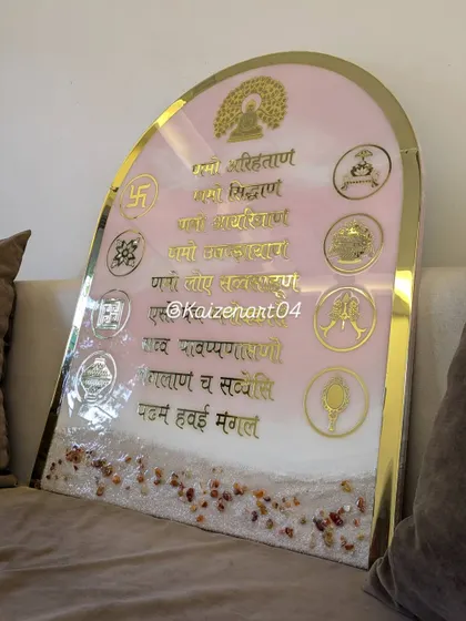 This Navkar Mantra frame features a unique pink ocean theme. The 24 by 30-inch arched piece combines the sacred mantra and symbols with a calming, beach-inspired background, including natural stones at the base.